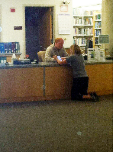 patron kneeling at the Reference desk